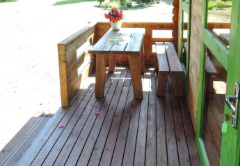 Véranda en bois avec table, bancs et fleurs à Holiday homes, Kodrabek-35 m², Allemagne.