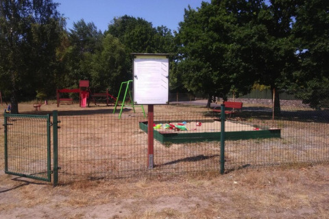 Parque infantil vallado con columpio, tobogán y arenero en la casa rural Kodrabek-35 m² en Alemania.