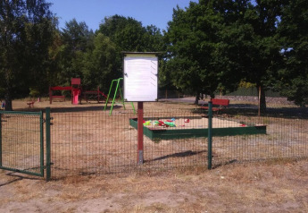 Eingezäunter Spielplatz mit Rutsche, Schaukel und Sandkasten am Ferienhaus Kodrabek-35 qm in Deutschland.