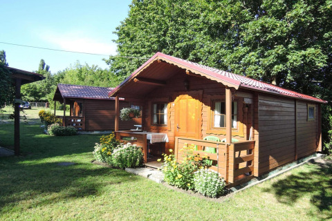 Bungalow in legno Lubin Tipo A Jolanta con veranda e fiori, fotografato d'estate in Germania.
