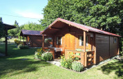 Cabaña de madera Bungalows Lubin Type A Jolanta con porche y flores en verano en Alemania.