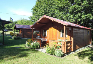 Bungalow in legno Lubin Tipo A Jolanta con veranda e fiori, fotografato d'estate in Germania.
