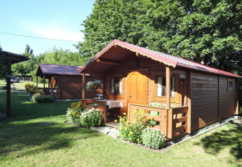 Cabaña de madera Bungalows Lubin Type A Jolanta con porche y flores en verano en Alemania.