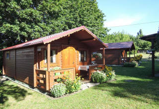 Bungalow in legno con veranda e fiori, immerso nel verde, Bungalows Lubin Tipo A Jolanta, Germania.