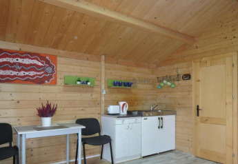 Vista interior de Bungalows Lubin Tipo A Jolanta en Alemania, con paredes de madera, cocina y mesa.