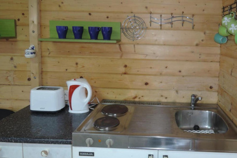 Piccola cucina in legno con lavello, fornelli, bollitore, tostapane e tazze in Bungalows Lubin Type A Jolanta.