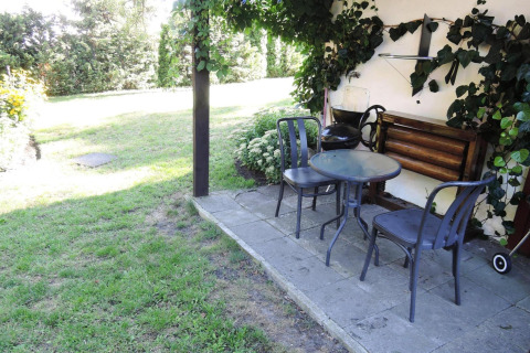 Patio at Bungalows Lubin Type A Jolanta in Germany with table, chairs, and greenery in a garden setting.
