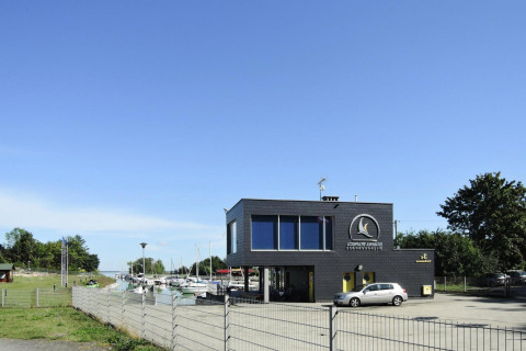 Edificio moderno scuro Bungalows Lubin Type A Jolanta vicino a un porto in Germania in una giornata di sole