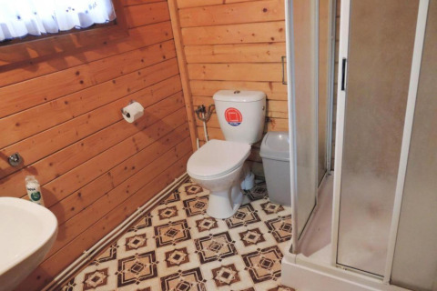 Salle de bain dans une cabane en bois avec toilettes, douche et sol rétro, Bungalows Lubin-Type B, Allemagne.