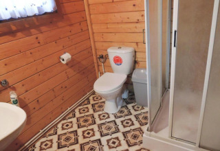 Salle de bain dans une cabane en bois avec toilettes, douche et sol rétro, Bungalows Lubin-Type B, Allemagne.