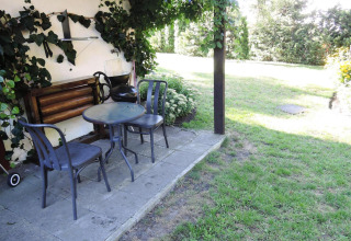 Outdoor terrace at Bungalows, Lubin-Type B (Henryk) in Germany with table, chairs, and a grassy garden.