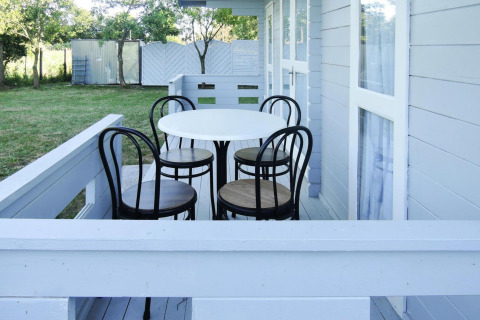 Bright porch with round table and four chairs at the cabin At «słonecznikiem» in Germany, surrounded by nature.