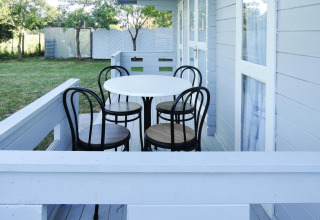 Bright porch with round table and four chairs at the cabin At «słonecznikiem» in Germany, surrounded by nature.