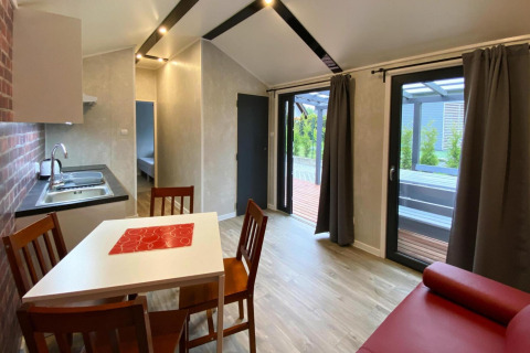 Moderne bungalow for 4 personer ved Bungalows Pirates i Dziwnow med køkken, spisebord og terrasse.