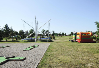 Parque infantil al aire libre con camas elásticas, castillo inflable y mini golf en la cabaña At «słonecznikiem», Alemania.