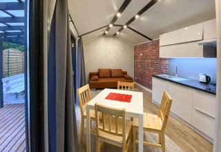 Binnenzicht van Bungalows Pirates in Dziwnow voor 4 personen met keuken, eettafel en zetel.