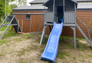Legeområde ved en hytte med rutsjebane, gynger og klatrestativ, set i Bungalows Pirates, Dziwnow, Tyskland.