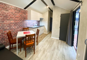 Moderna cabaña con pared de ladrillo, comedor y cocina en Bungalows Pirates en Dziwnow, Alemania.