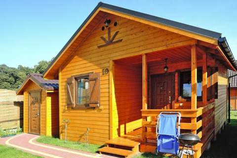 Gemütliche Holzlodge im Ferienresort Wiselka mit Veranda, Grill und Gartenstuhl, gelegen in Deutschland.