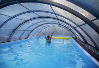 Indoor pool with a transparent dome roof at Holiday Resort Wiselka-35 sqm Type A in Germany.