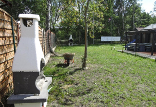 Tuinzicht bij Bungalows Pirates in Dziwnow voor 6 personen met barbecue en veel groen rondom.
