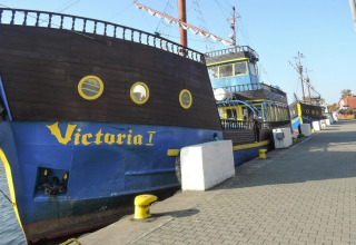 Billedet viser et piratskib kaldet Victoria I, fortøjet ved en kaj i Dziwnow, Polen, i solskin.