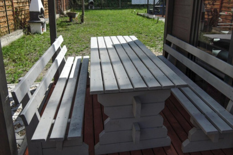 Houten buitentafel met banken bij Bungalows Pirates in Dziwnow voor 6 personen, Duitsland, zonnig.