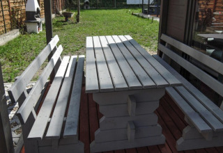 Houten buitentafel met banken bij Bungalows Pirates in Dziwnow voor 6 personen, Duitsland, zonnig.
