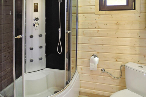 Bagno moderno con box doccia e pareti in legno nel resort Wiselka-35 mq Tipo A in Germania.