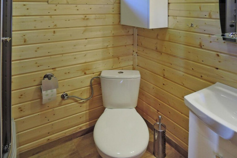 Bagno moderno con WC e pannelli in legno al Holiday Resort Wiselka Tipo A in Germania.