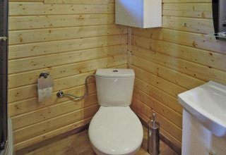 Modern toilet in a wooden-paneled bathroom at Holiday Resort Wiselka-35 sqm Type A in Germany.