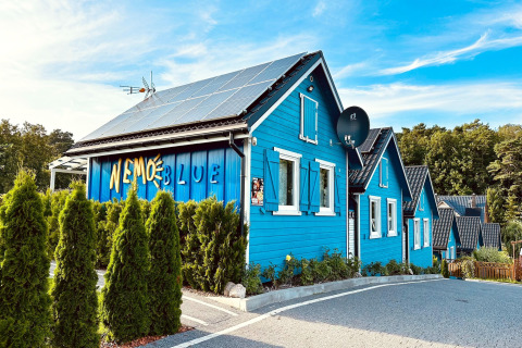 Case vacanza blu con pannelli solari e insegna 'Nemo Blue' al resort Wiselka in Germania.
