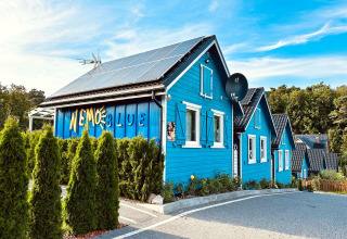 Blauwe vakantiewoningen met zonnepanelen en bord 'Nemo Blue' bij Holiday Resort Wiselka in Duitsland.