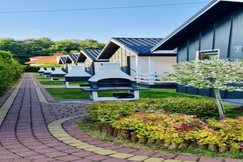 Row of lodges with outdoor barbecues and garden at Holiday Resort with the pool Wiselka in Germany.