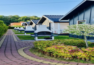 Row of lodges with outdoor barbecues and garden at Holiday Resort with the pool Wiselka in Germany.