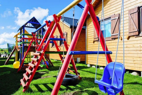 Kleurrijke speelplaats met schommels en klimrek bij Holiday resort with the pool Wiselka in Duitsland.