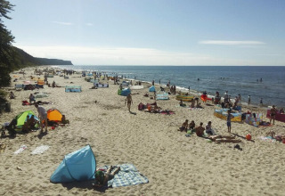 Beach scene at Holiday resort with the pool Wiselka-35 sqm Type A in Germany, with people and sunshades.