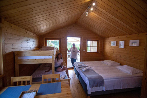 Houten lodge met tweepersoonsbed, stapelbed en eethoek bij Holiday homes in Miedzyzdroje, Duitsland.