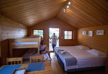 Chalet en bois avec lit double, lits superposés et coin repas à Holiday homes in Miedzyzdroje, Allemagne.