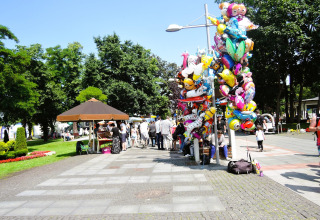 Mensen verzamelen zich bij Holiday homes in Miedzyzdroje, Duitsland, met ballonnen en kraampjes om zich heen.
