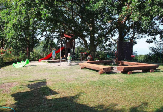 Speeltuin met glijbaan, zandbak en kinderen bij vakantiehuizen in Miedzyzdroje, Duitsland.