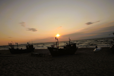 Sunset over the beach with fishing boats, viewed from holiday homes in Miedzyzdroje for 4 persons.
