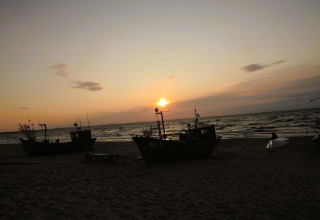 Zonsondergang aan het strand met vissersboten vanuit vakantiehuizen in Miedzyzdroje voor 4 personen.