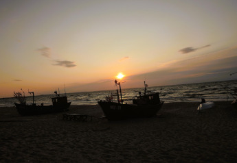 Atardecer en la playa con barcos de pesca, visto desde casas de vacaciones en Miedzyzdroje para 4 personas.