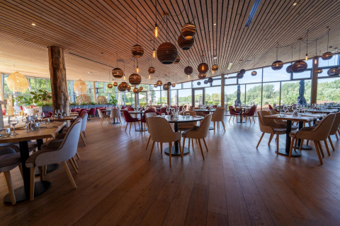 Spacious, stylish restaurant at The Lodge by YourNature with wood decor and panoramic window views.