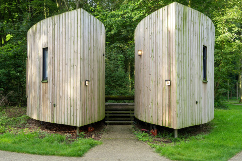 To moderne tiny houses af træ, The Lodge af YourNature, omgivet af skovområder og grønne omgivelser.