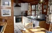 Accogliente cucina nello chalet Five Waterings nel Regno Unito, con pareti in legno e elettrodomestici moderni.