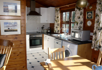 Accogliente cucina nello chalet Five Waterings nel Regno Unito, con pareti in legno e elettrodomestici moderni.