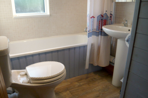 Billede af et badeværelse med badekar, toilet og håndvask i et chalet kaldet Five Waterings, Storbritannien.