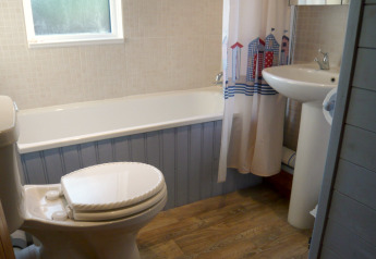 Foto di un bagno con vasca, toilette e lavandino presso il chalet Five Waterings, Regno Unito.